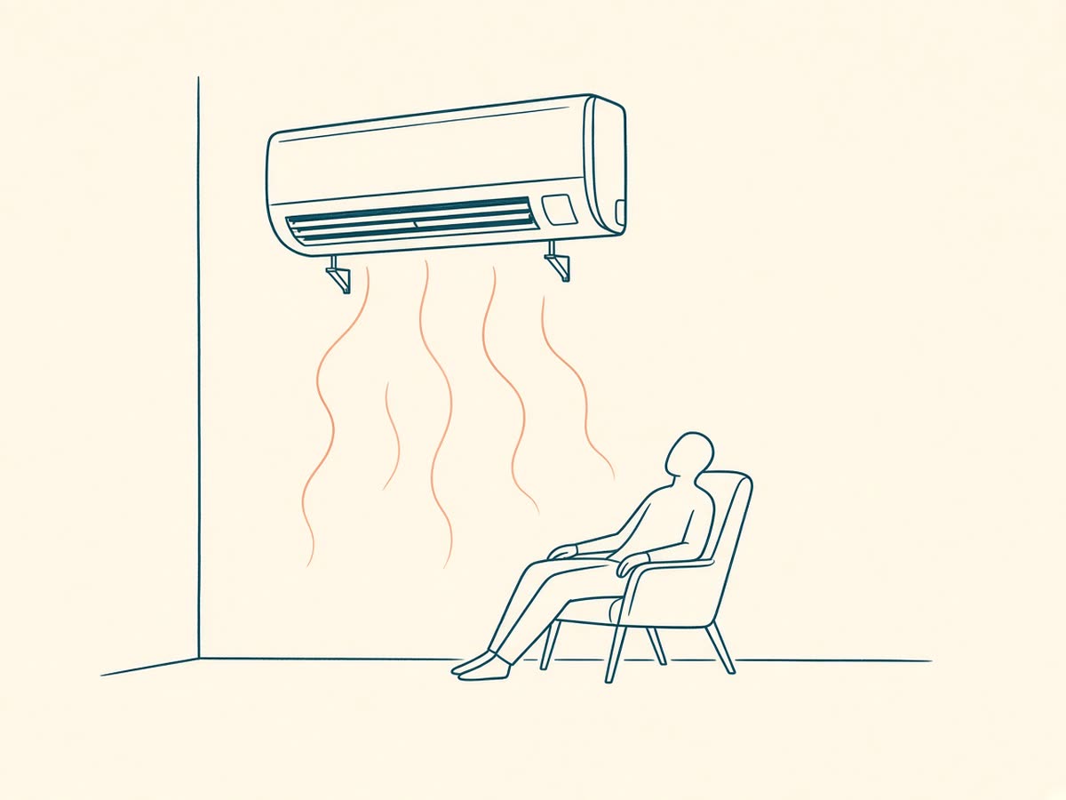 Line drawing of a wall-mounted mini-split above a person resting in a cool room.