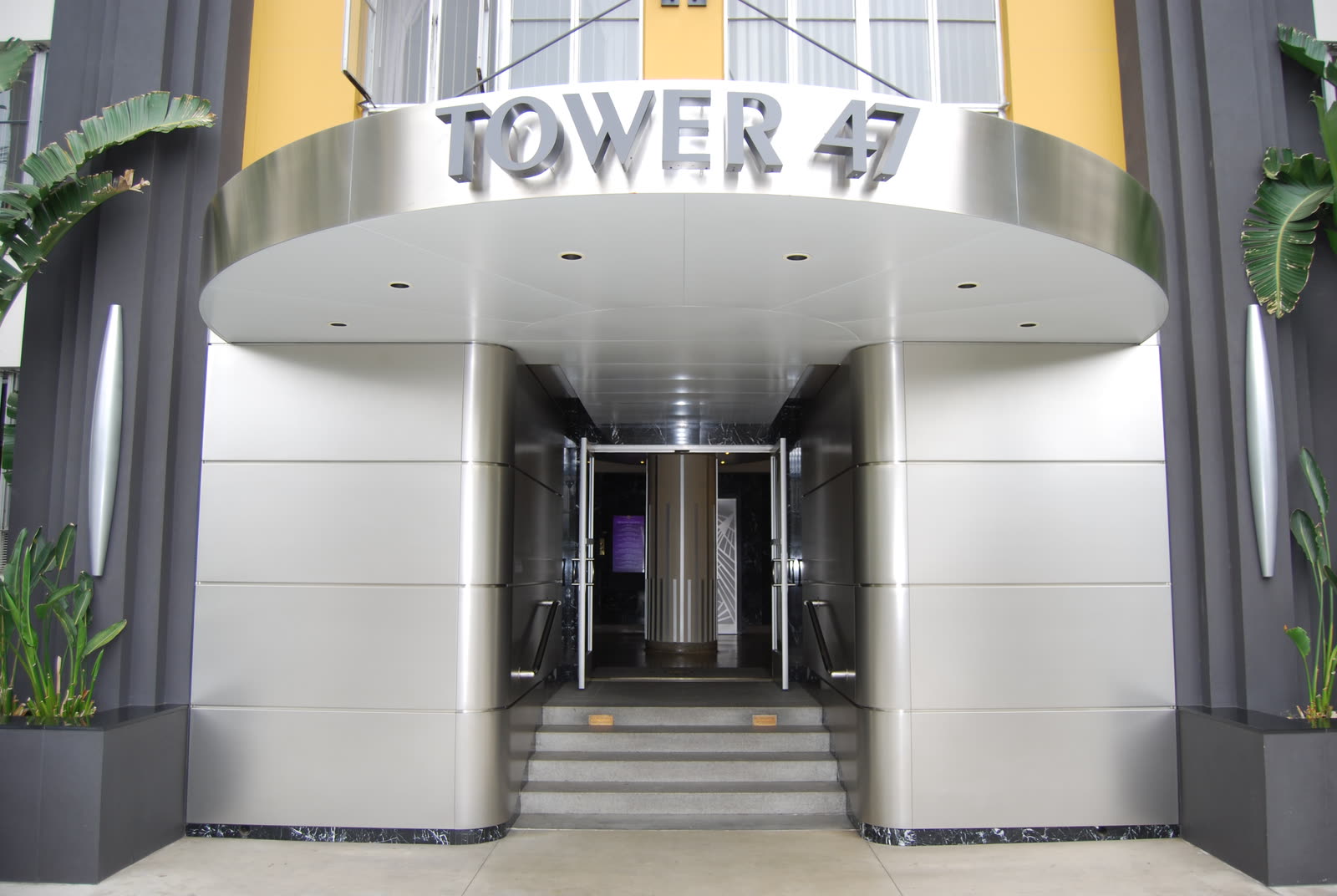 Stainless-steel building entry with a metal canopy, architectural metal work by K.D. Clark Construction.