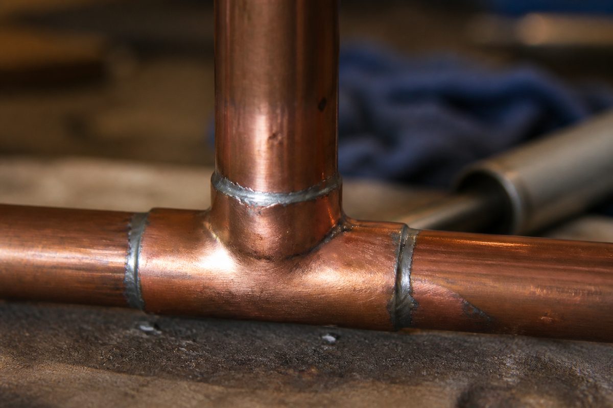 Close-up of a freshly soldered copper pipe fitting.