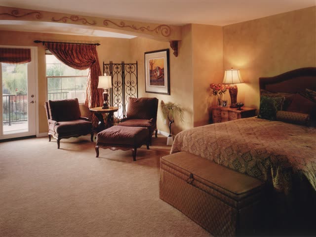 Upholstered chairs and ottoman with a storage bench in a client bedroom.